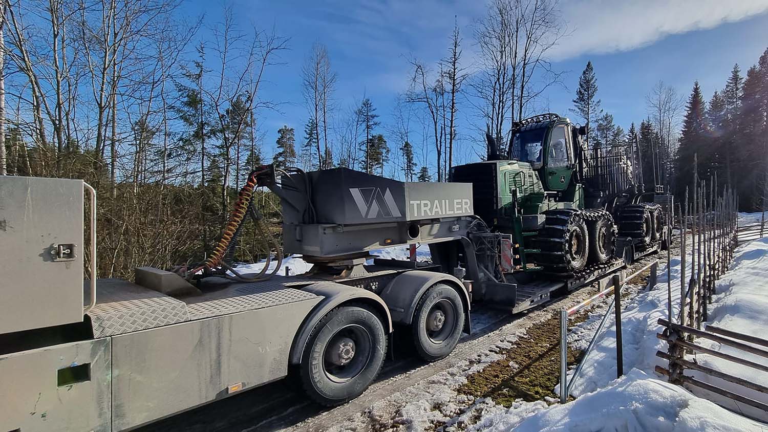 En skogsmaskinstrailer med en skogsmaskin på